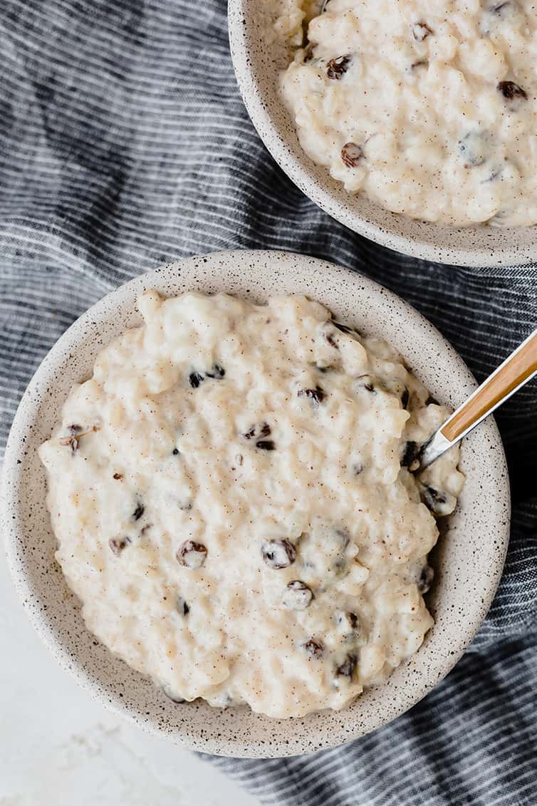 Two bowls of rice pudding with bourbon-soaked raisins.