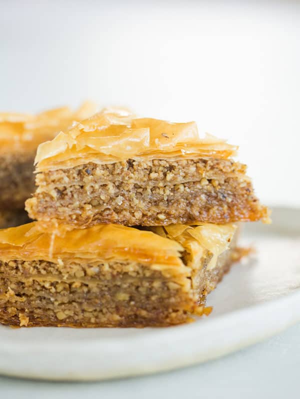 Triangles of baklava stacked on a plate.