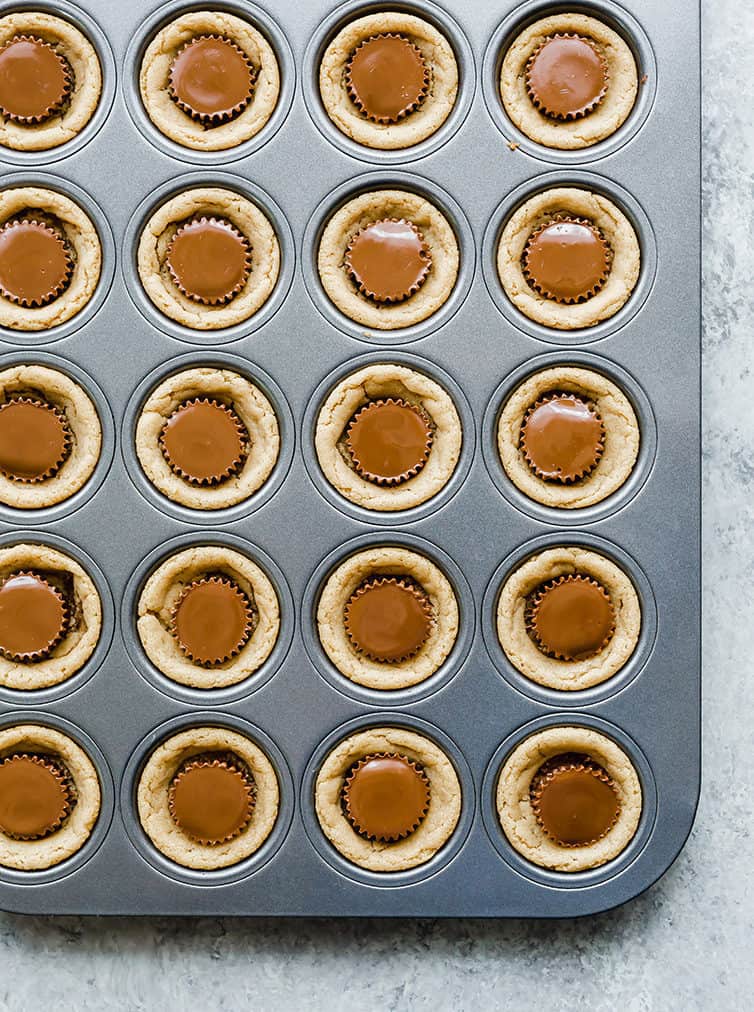 A mini muffin pan full of peanut butter cup cookies.