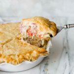 A slice of Italian Easter Pie being lifted out of the pie plate.