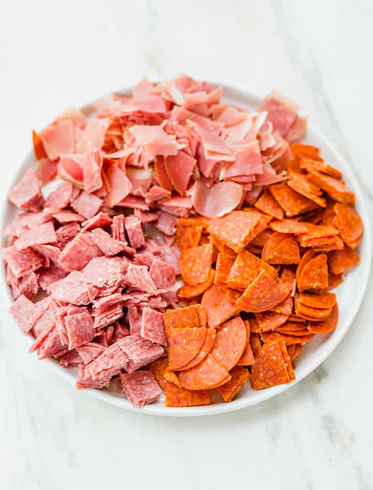 A plate of chopped pepperoni, salami and prosciutto.