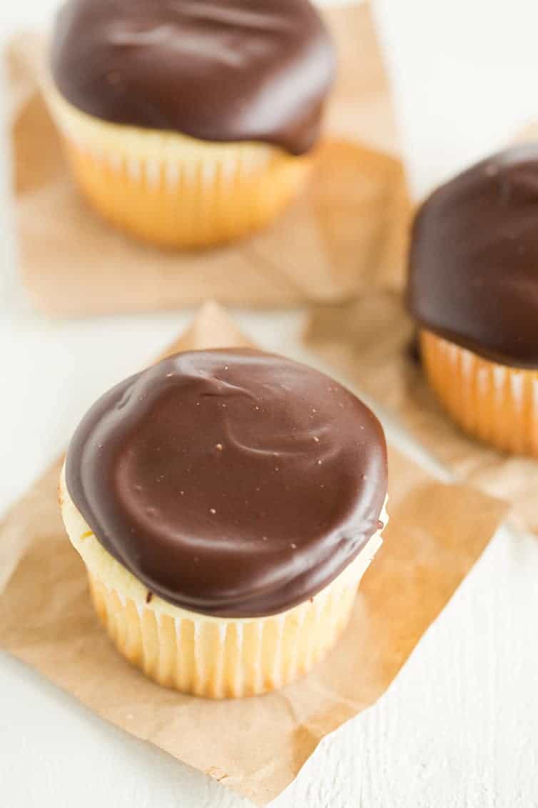 Boston Cream Cupcakes - Vanilla cupcakes filled with pastry cream and topped with chocolate ganache.