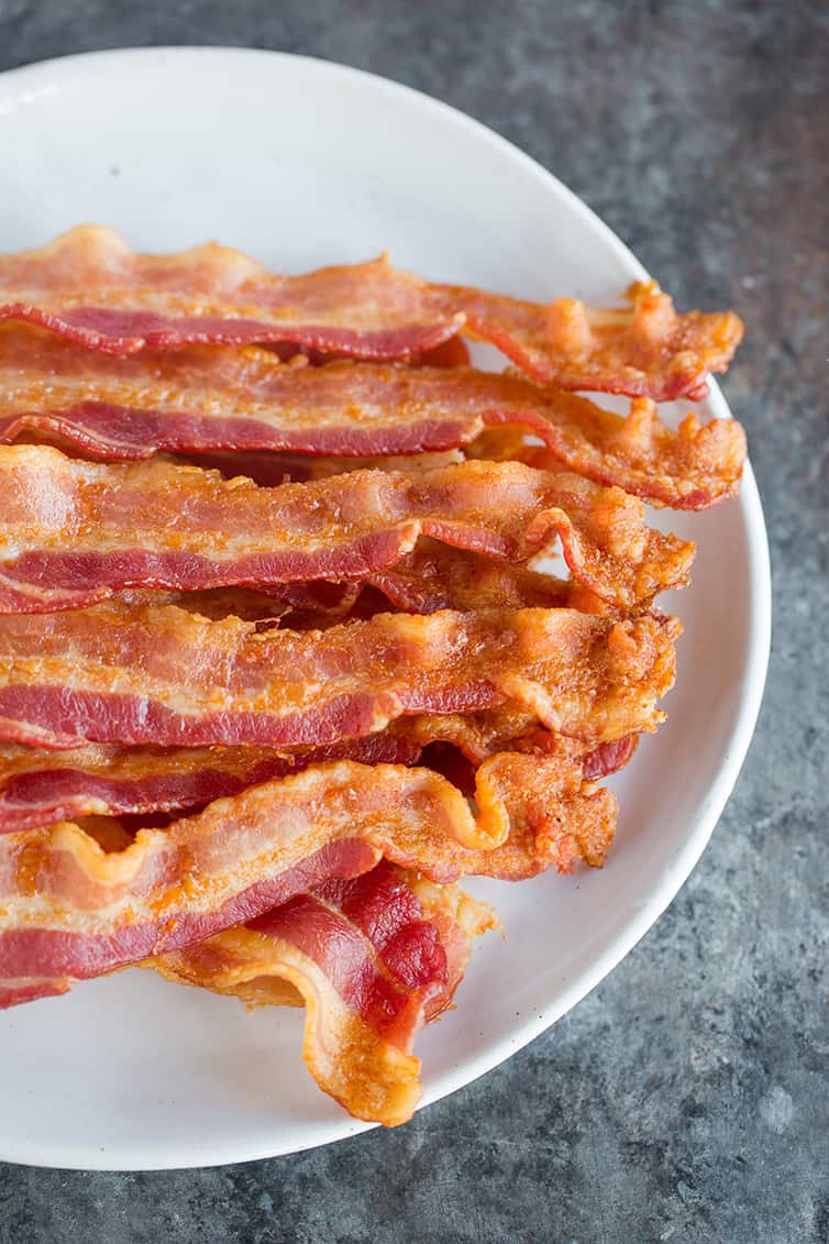 A plate with slices of oven baked bacon.