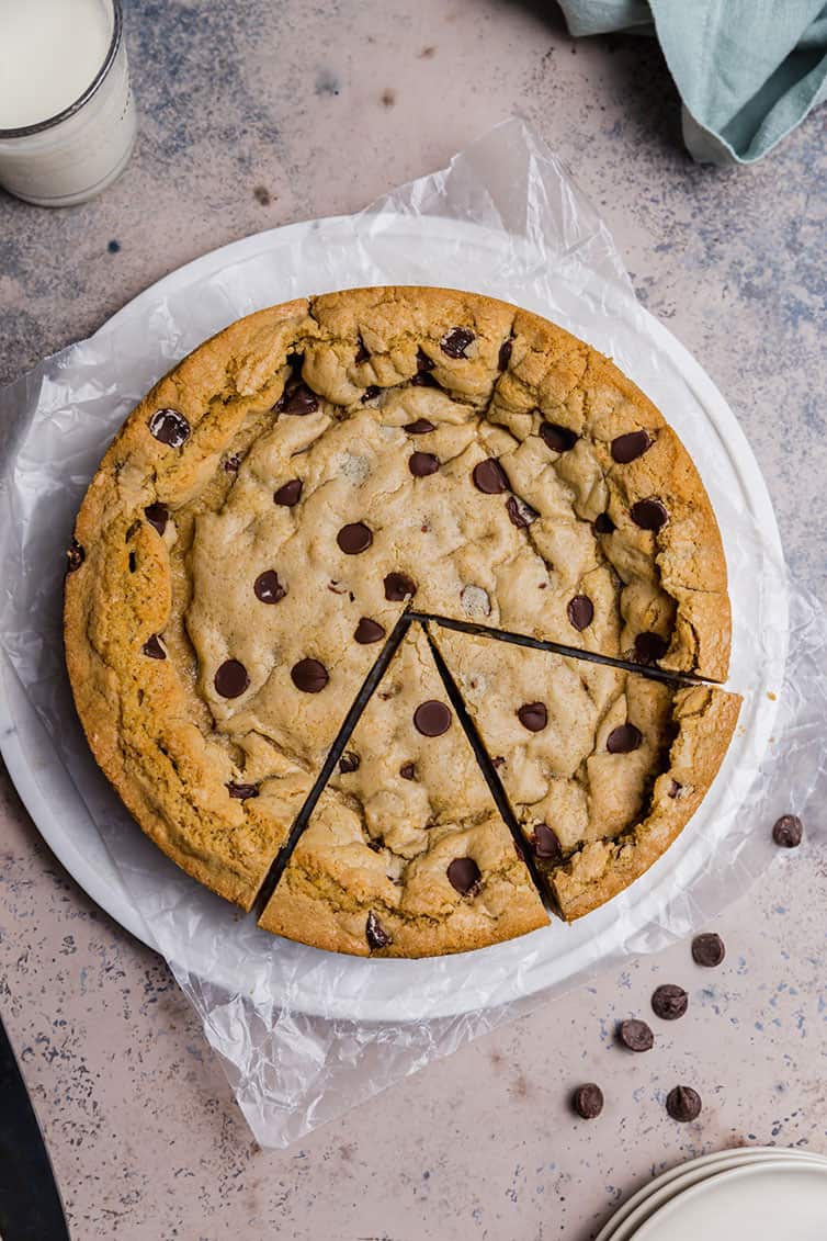 Overhead photo of chocolate chip cookie cake with two slices cut.