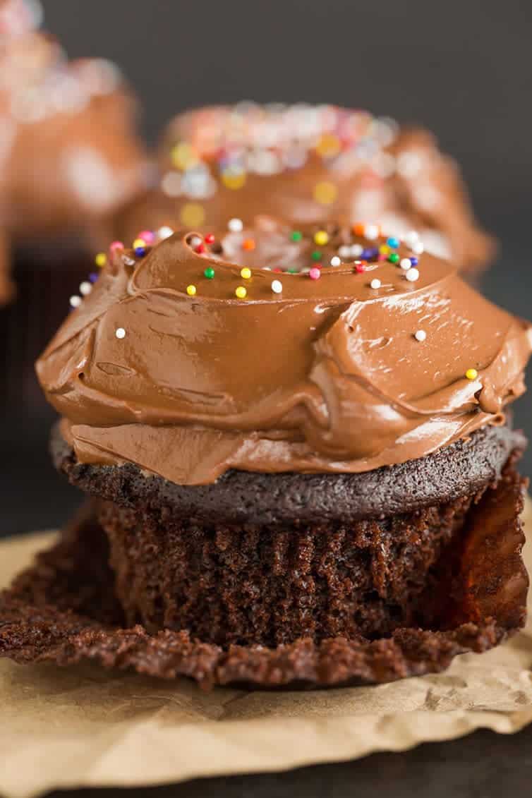 Chocolate cupcake with the paper liner partially peeled away.