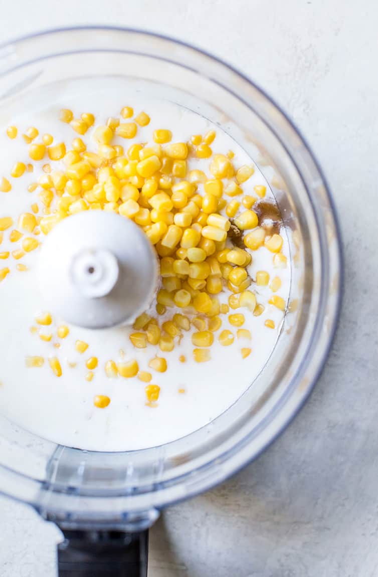 Corn and buttermilk for cornbread in a food processor.