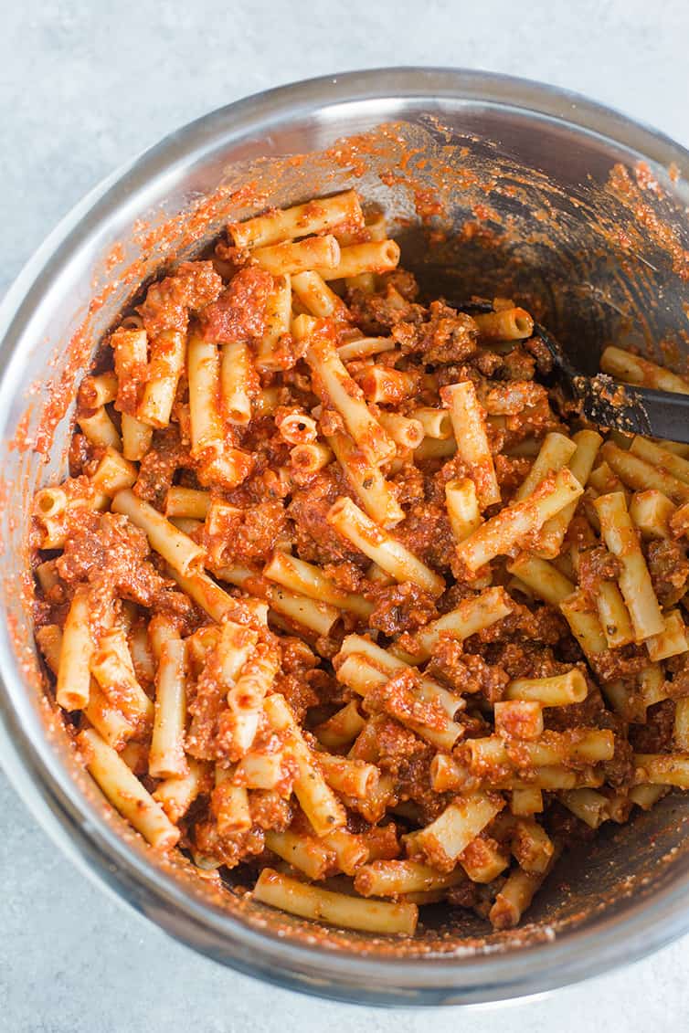 Prepped baked ziti mixed together in a big bowl.