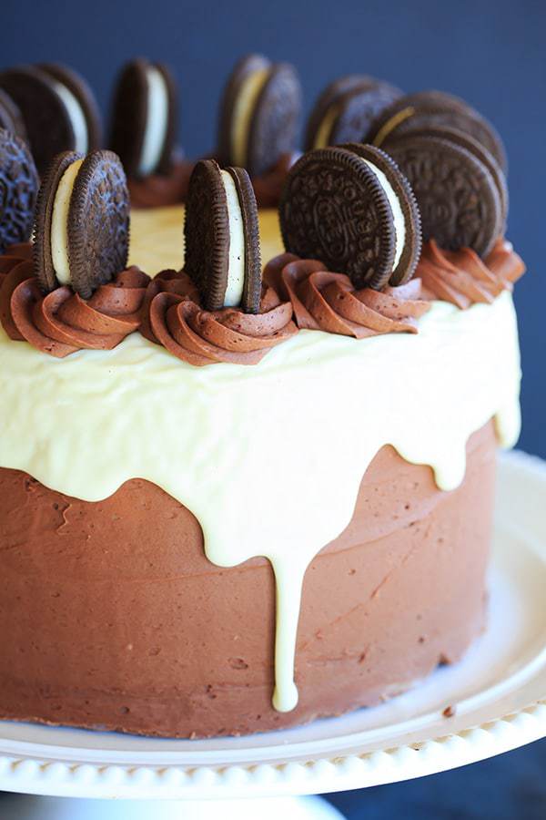 The ULTIMATE Cookies and Cream Oreo Cake - A triple layer chocolate cake with cookies and cream filling, chocolate fudge frosting, white chocolate glaze and more Oreos on top! | https://www.browneyedbaker.com/cookies-and-cream-oreo-cake/