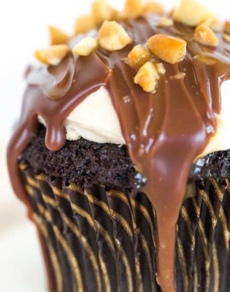 These Snickers cupcakes taste JUST like the candy bar... A chocolate cupcake filled with peanut nougat, topped with a caramel buttercream frosting, covered in a chocolate ganache, chopped peanuts and a drizzle of caramel sauce.