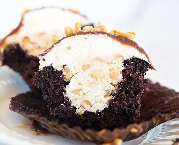 These Snickers cupcakes taste JUST like the candy bar... A chocolate cupcake filled with peanut nougat, topped with a caramel buttercream frosting, covered in a chocolate ganache, chopped peanuts and a drizzle of caramel sauce.