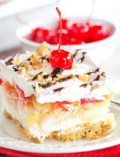 No Bake Banana Split Dessert is a classic! It layers a graham cracker crust, cream cheese-based filling, bananas, pineapple, strawberries, whipped cream, nuts, chocolate & a cherry on top!