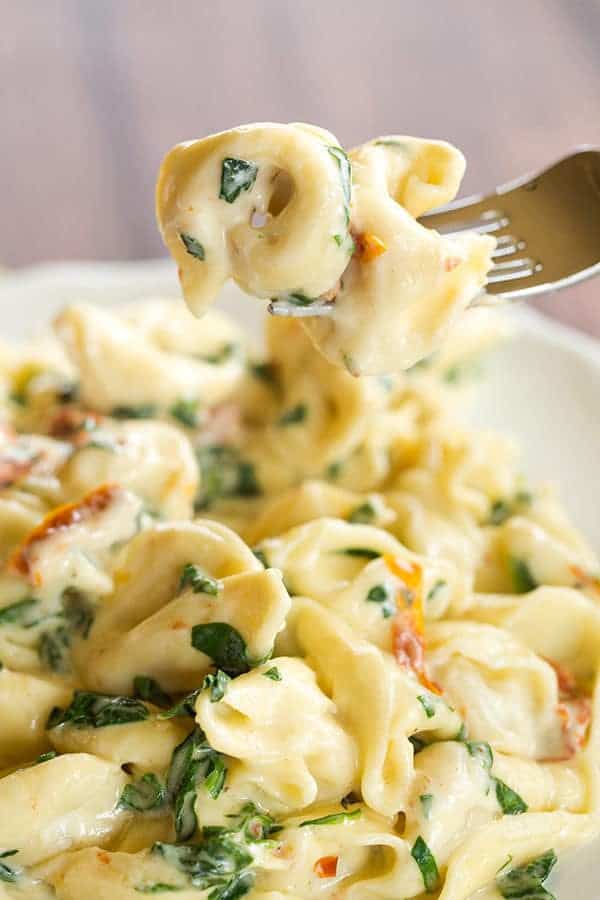 Tortellini in Parmesan-Cream Sauce with Spinach and Sun-Dried Tomatoes - An easy, AMAZING dinner ready in less than 30 minutes! Perfect for a weeknight meal or your next dinner party.