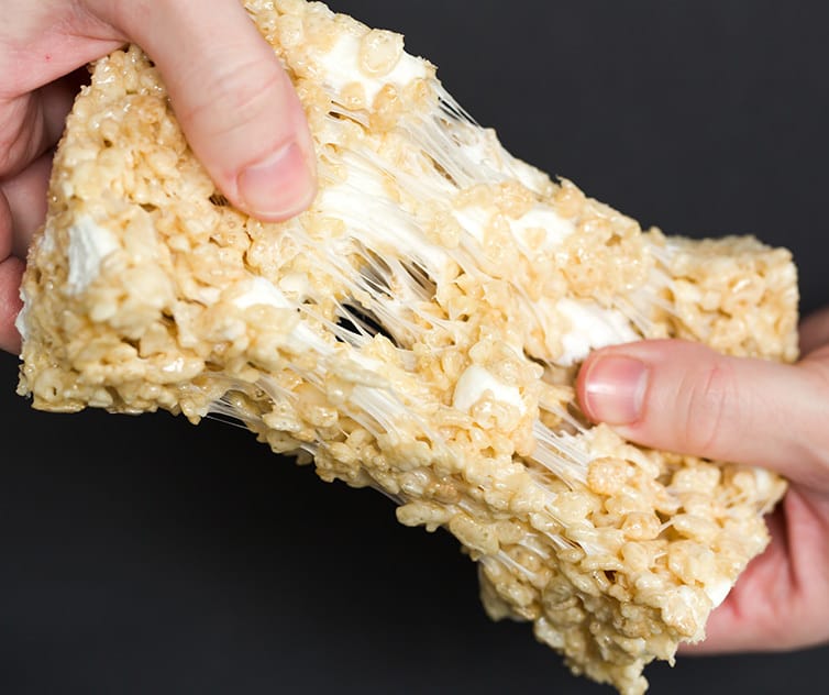 A gooey rice krispie treat being pulled apart.