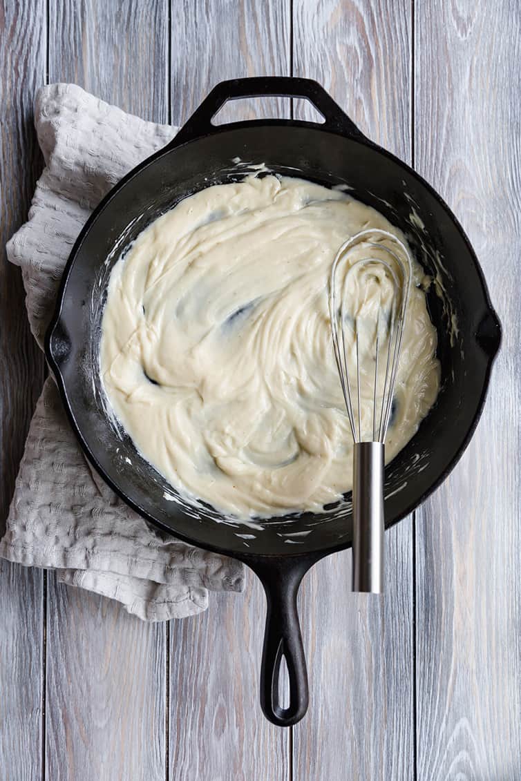 Potato salad dressing whisked in a cast iron skillet.