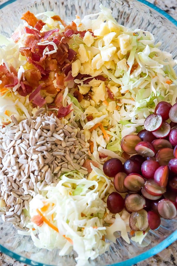 A loaded cole slaw recipe loaded with cheese, bacon, grapes, and sunflower seeds. A great addition to your summer picnic!