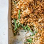 A pan of green bean casserole with a corner scooped out.