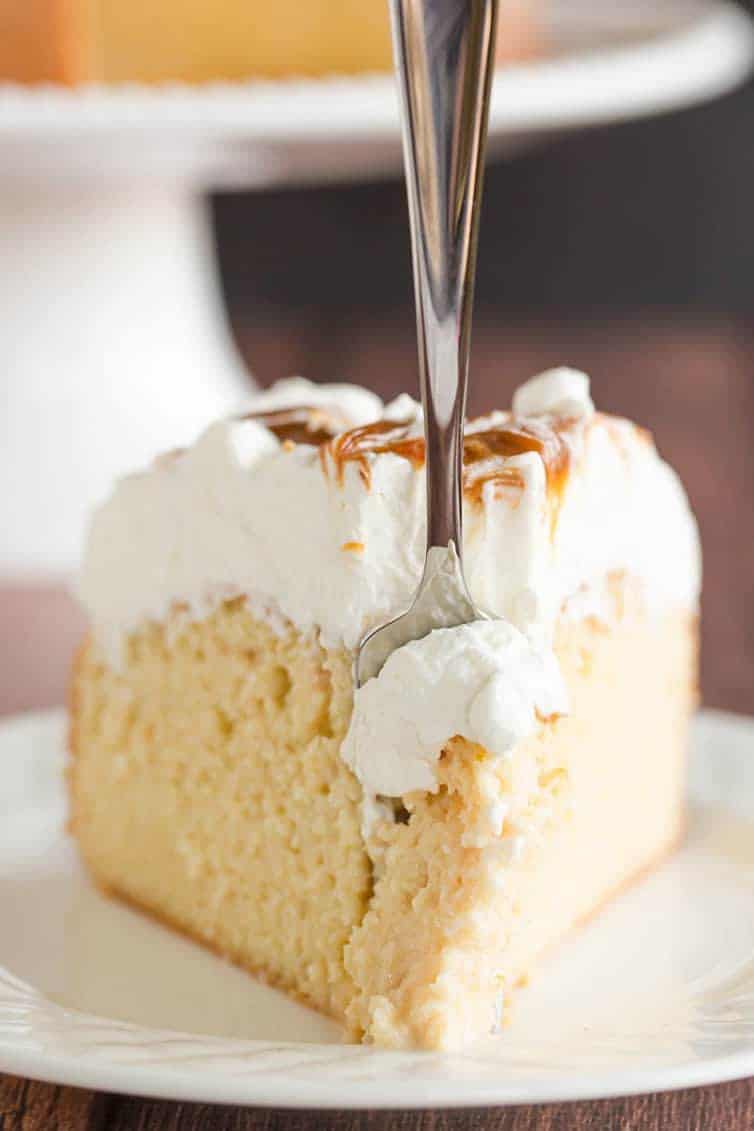 Take a big forkful of a slice of caramel tres leches cake.