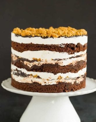 A s'mores layer cake sitting on a cake pedestal.