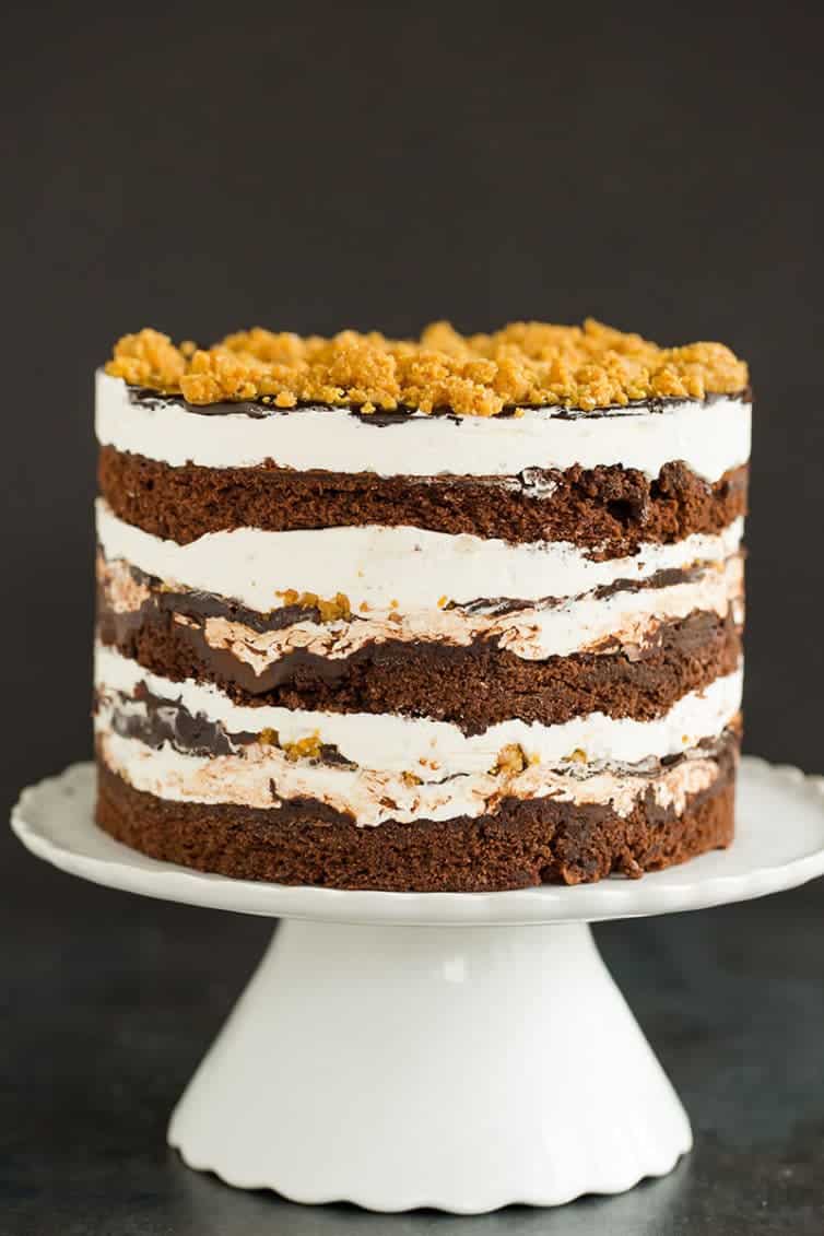 A s'mores layer cake sitting on a cake pedestal.