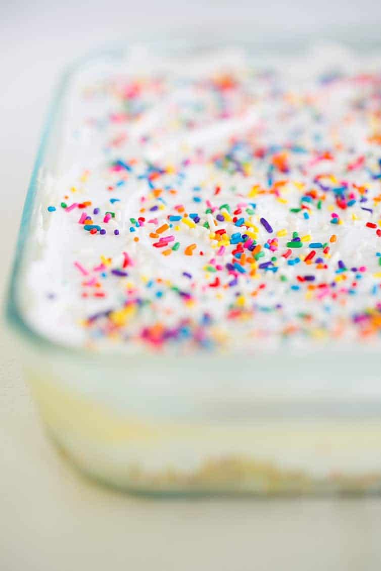 A pan of no bake funfetti lush dessert covered in sprinkles!