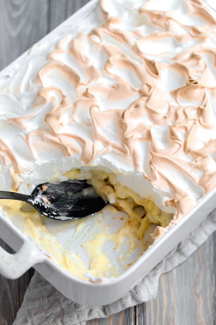 A pan of banana pudding with a corner scooped out.