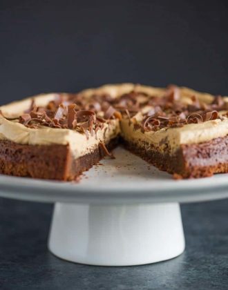 Brownie Cake with Cookie Butter Frosting on a serving platter with a slice missing.