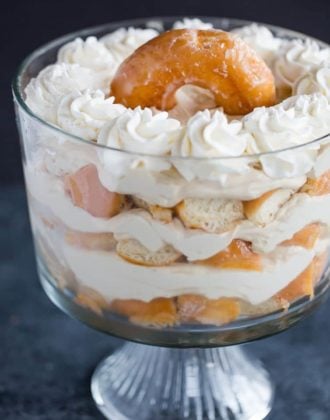 Layers of chopped doughnuts and coffee whipped cream in a trifle bowl.