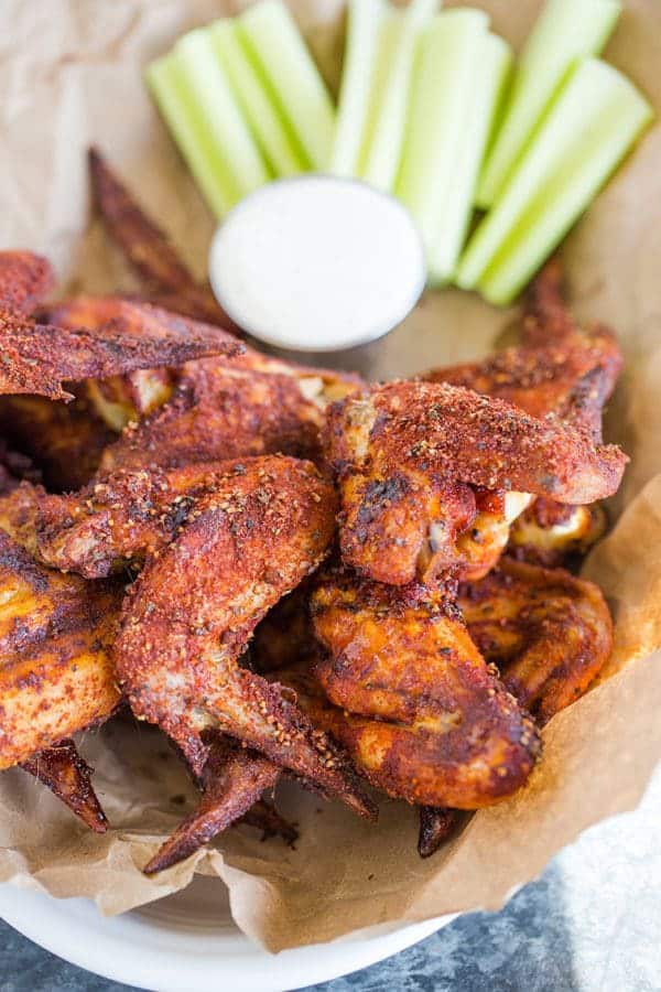A basket of chicken wings with celery and ranch dressing.