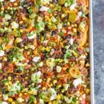 A sheet pan full of loaded nachos.