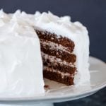 Devil's food cake on a cake stand with a slice of cake removed.