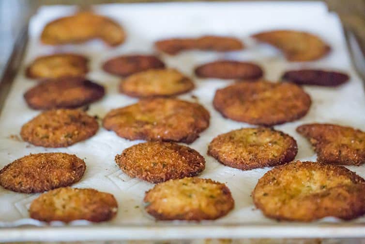 Fried eggplant slices draining on paper towels.