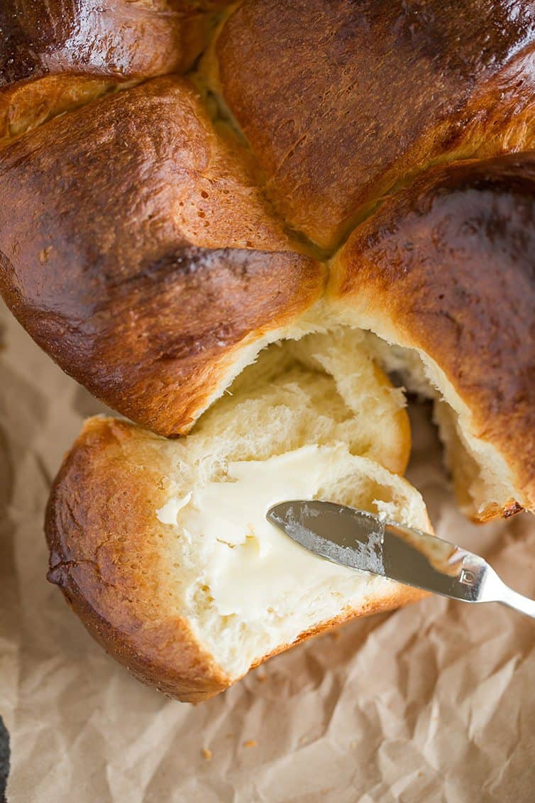 Pull-apart milk bread being spread with butter.