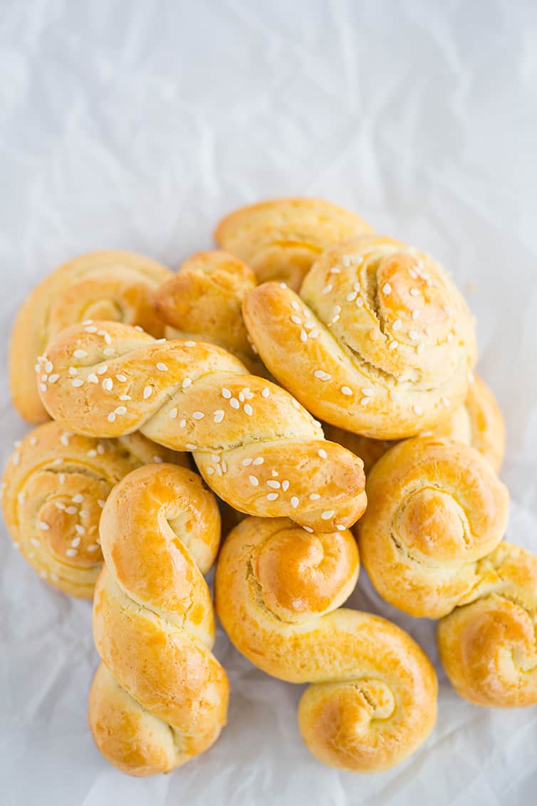 A pile of Koulourakia (Greek Easter cookies) on parchment paper.