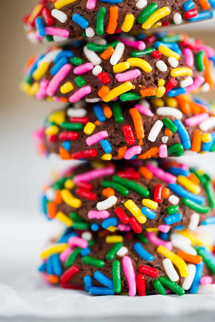 A stack of chocolate crinkle cookies rolled in sprinkles.