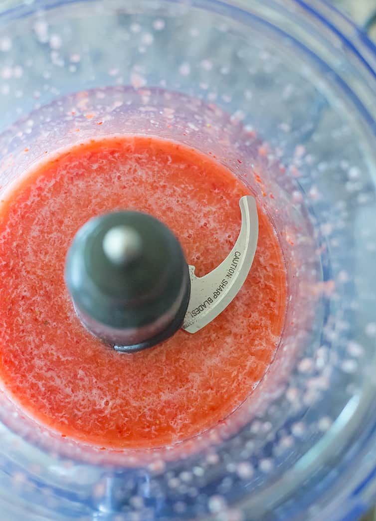 Strawberry puree in the bowl of a food processor.