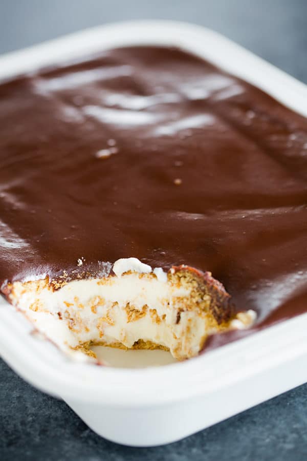 A pan of Chocolate Eclair Cake with a scoop taken out of the corner.