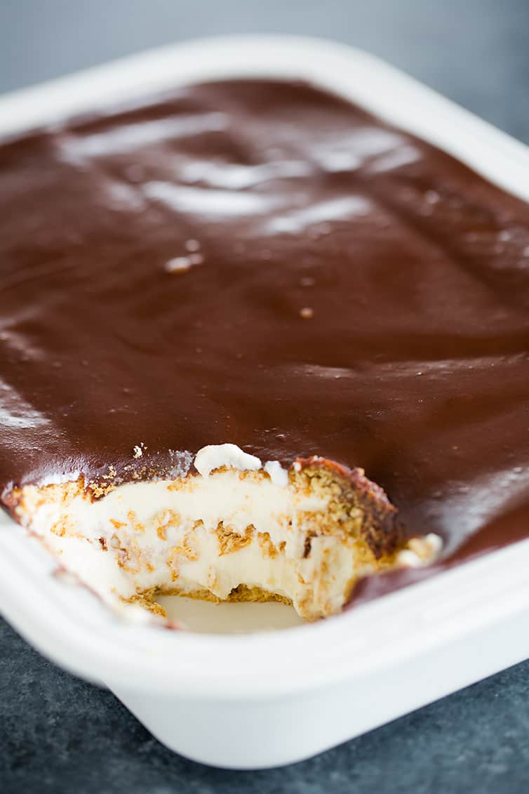 A pan of Chocolate Eclair Cake with a scoop taken out of the corner.
