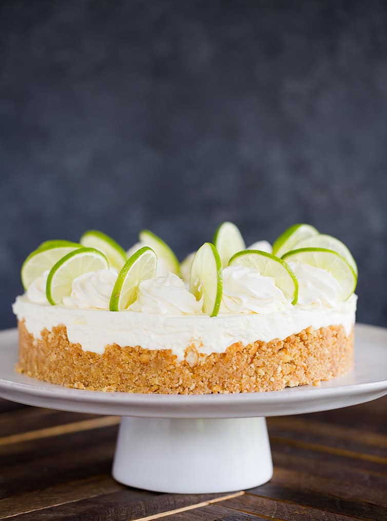 A key lime cheesecake on a serving platter.