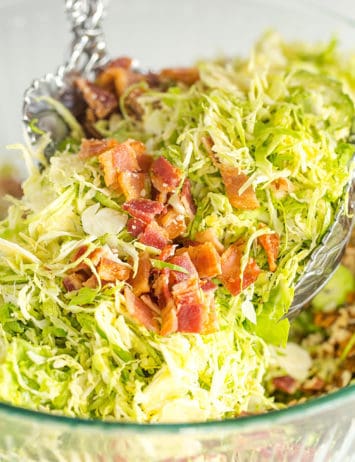 Tossing brussels sprouts salad with bacon, pecans and Parmesan cheese.