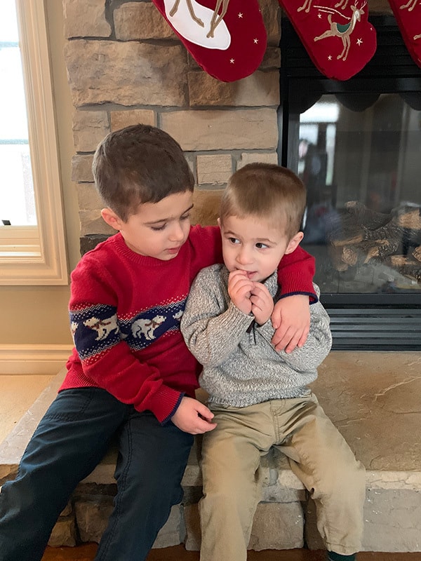 Joseph and Dominic sitting on the fireplace together.