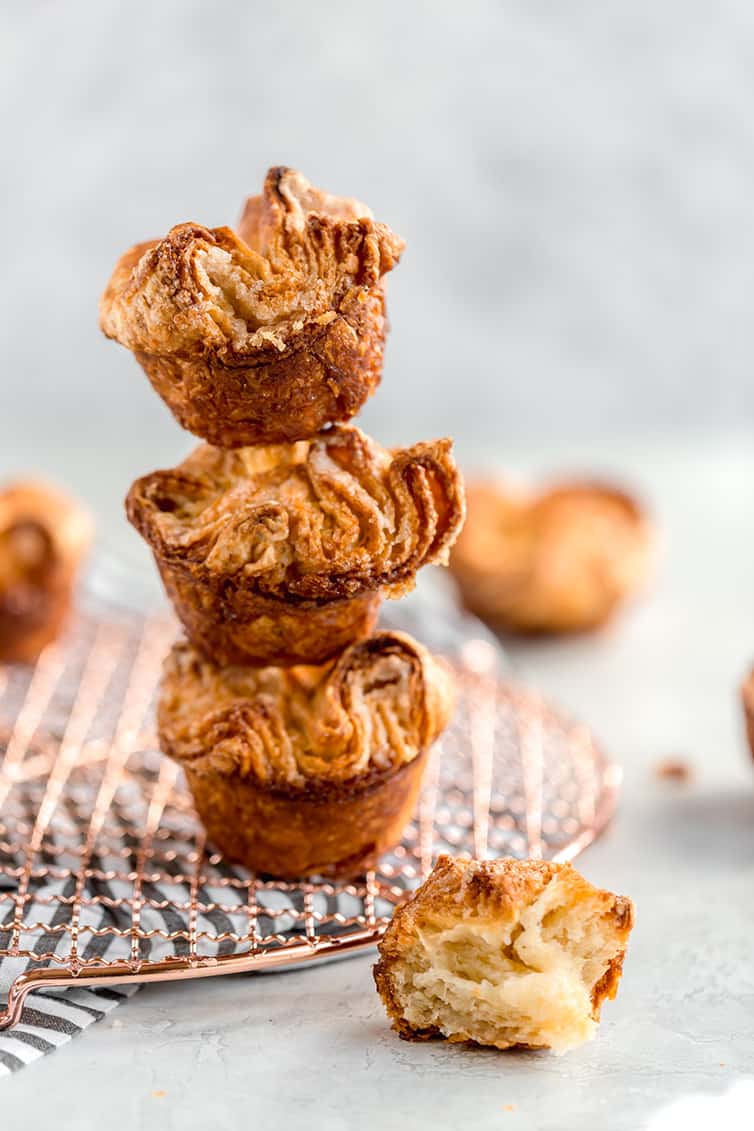 Three kouign-amann pastries stacked with one half-eaten in front.