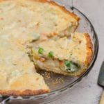 Chicken pot pie on a counter with a slice cut and ready to serve