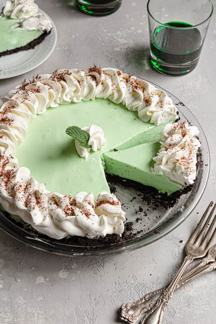 A grasshopper pie with a slice removed and another cut away from the whole pie.