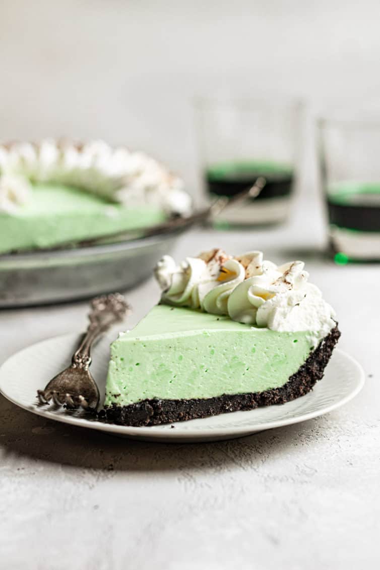 A slice of grasshopper pie on a plate with a fork.