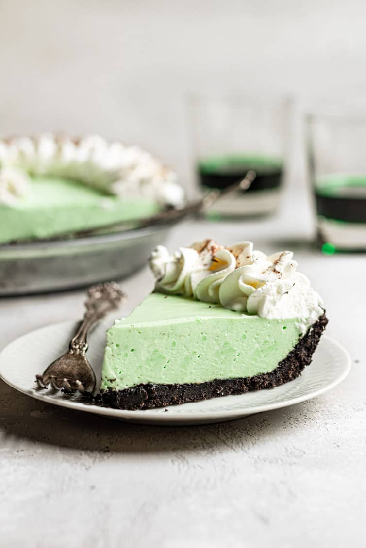 A slice of grasshopper pie on a plate with a fork.