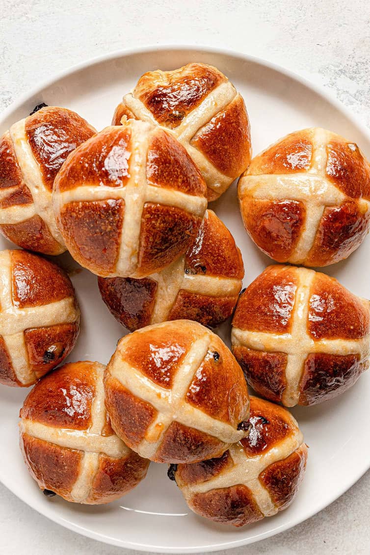 White plate piled high with hot cross buns.
