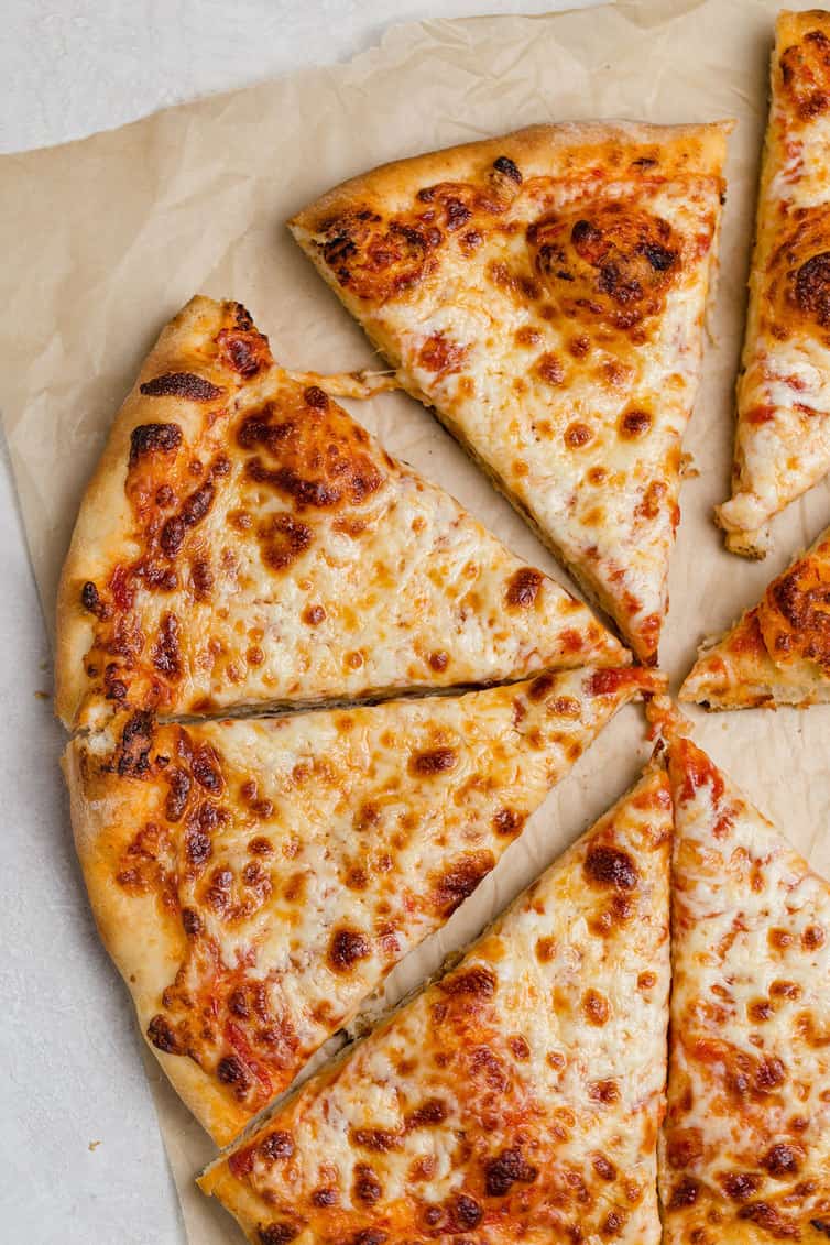 Half of a cheese pizza cut into triangle slices.