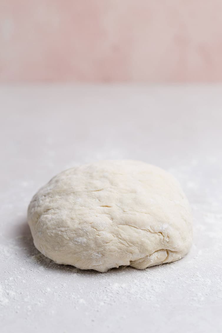 A ball of pizza dough on the counter.