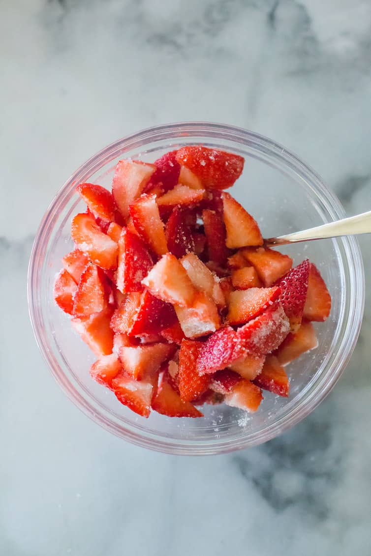 Macerated strawberries in a glass bowl.