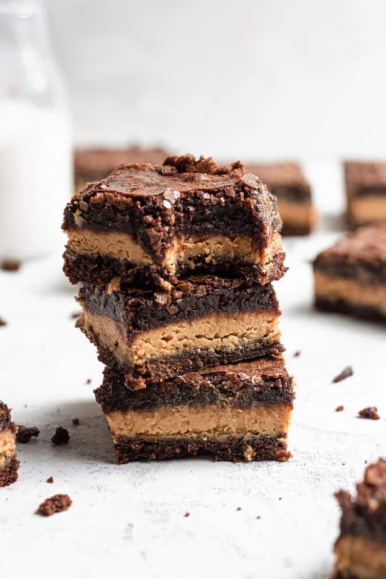 A stack of peanut butter brownies with a bite taken out of the top one.